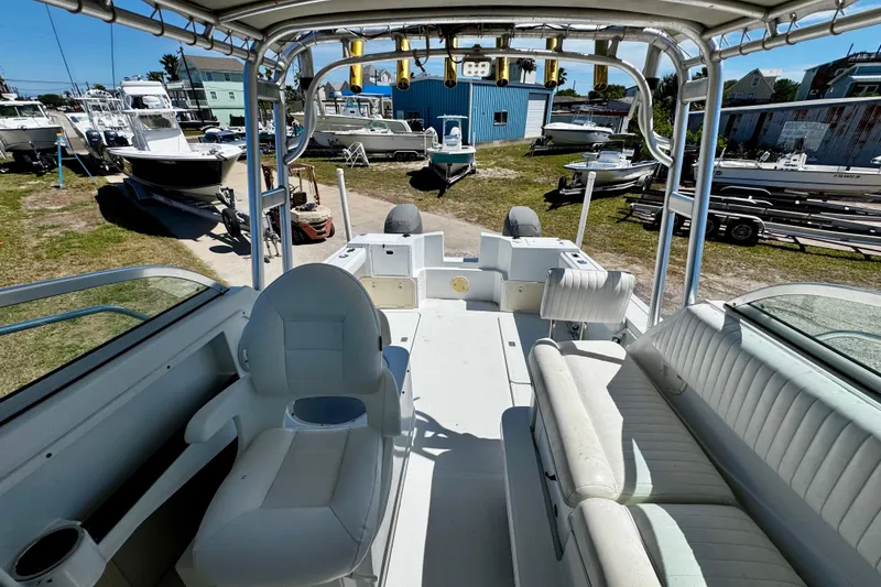 Slide: The Image of 2000 Glacier Bay 2670 Isle Runner boat interior with seating and helm, docked outdoors. - 26
