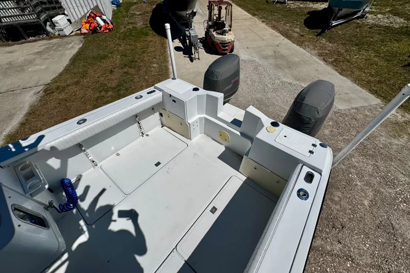 Slide: The Image of 2000 Glacier Bay 2670 Isle Runner boat deck with dual engines, parked outdoors. - 32