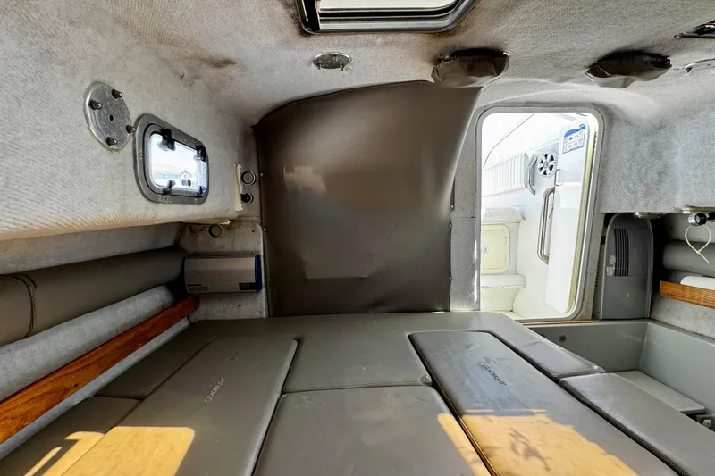 Slide: The Image of Interior cabin of 2000 Glacier Bay 2670 Isle Runner boat, featuring cushioned seating and compact design. - 35