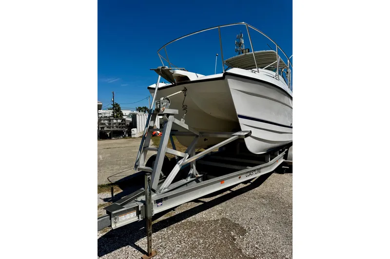 Slide: The Image of 2000 Glacier Bay 2670 Isle Runner boat on trailer under clear blue sky. - 4