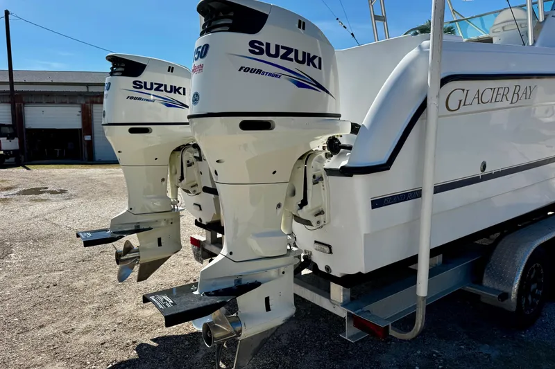 Slide: The Image of 2000 Glacier Bay 2670 Isle Runner with twin Suzuki outboard motors on a trailer. - 9