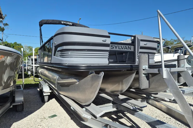 The Image of 2026 Sylvan R-22 CLZ DH pontoon boat on trailer under clear blue sky. - 1