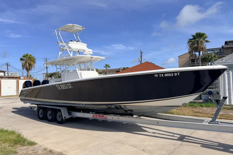 Slide: The Image of 2008 SeaHunter 40 Tournament boat on trailer, parked near buildings and palm trees. - 2