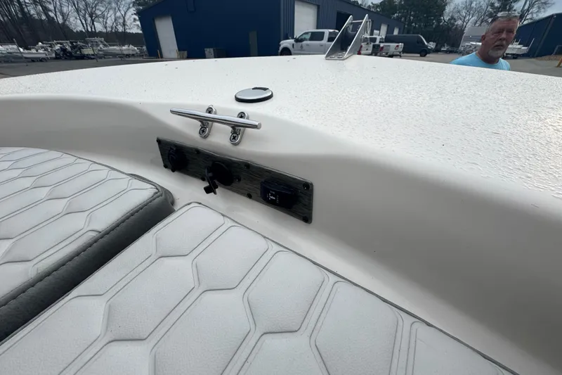 Slide: The Image of 2024 Carolina Skiff 192 JLS boat interior with white cushioned seating and control panel. - 10