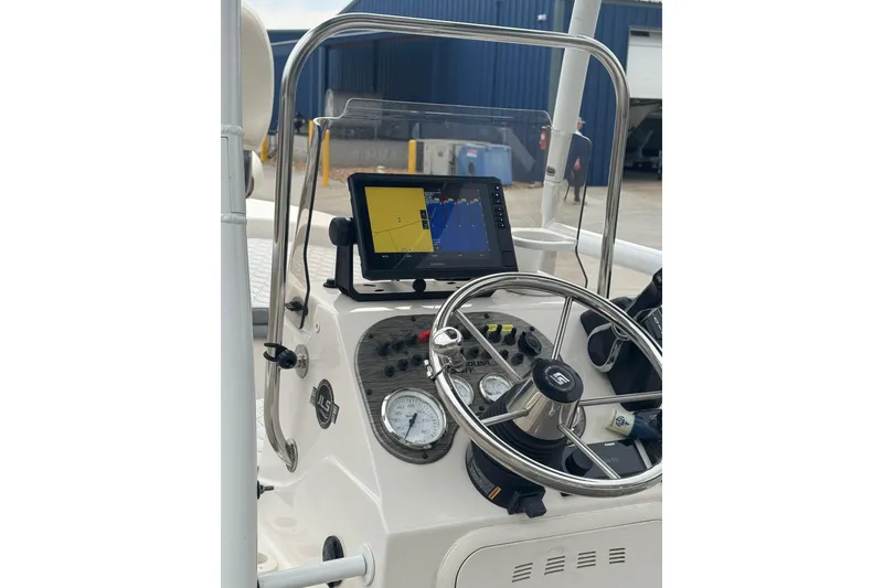 Slide: The Image of 2024 Carolina Skiff 192 JLS boat dashboard with steering wheel and navigation display. - 12