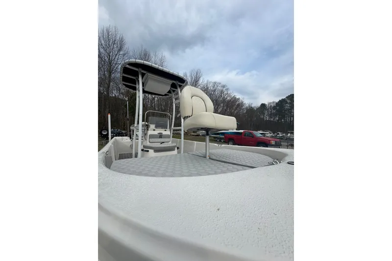 Slide: The Image of 2024 Carolina Skiff 192 JLS boat with seating and canopy, parked outdoors. - 9