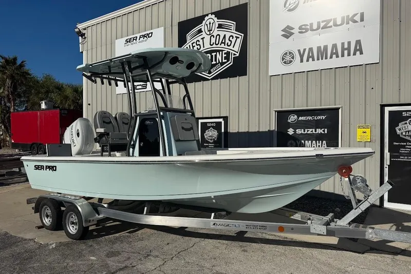 The Image of 2026 Sea Pro 210 Bay boat on trailer outside marine service center. - 0