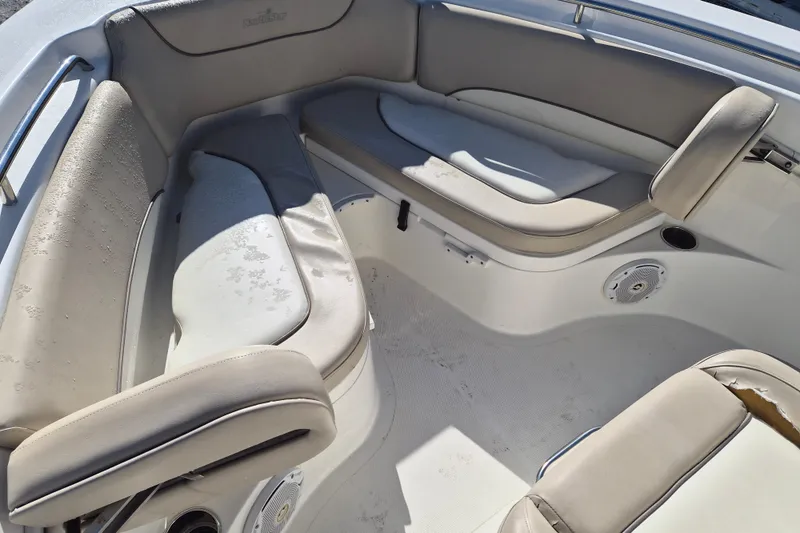 Slide: The Image of 2017 NauticStar 2102 Legacy boat interior with beige seating and cup holders. - 11