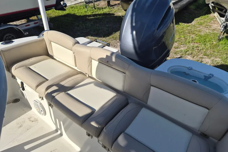Slide: The Image of 2017 NauticStar 2102 Legacy boat interior with beige seating and motor view. - 4
