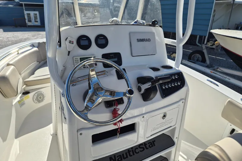 Slide: The Image of 2017 NauticStar 2102 Legacy boat console with steering wheel and Simrad navigation system. - 5