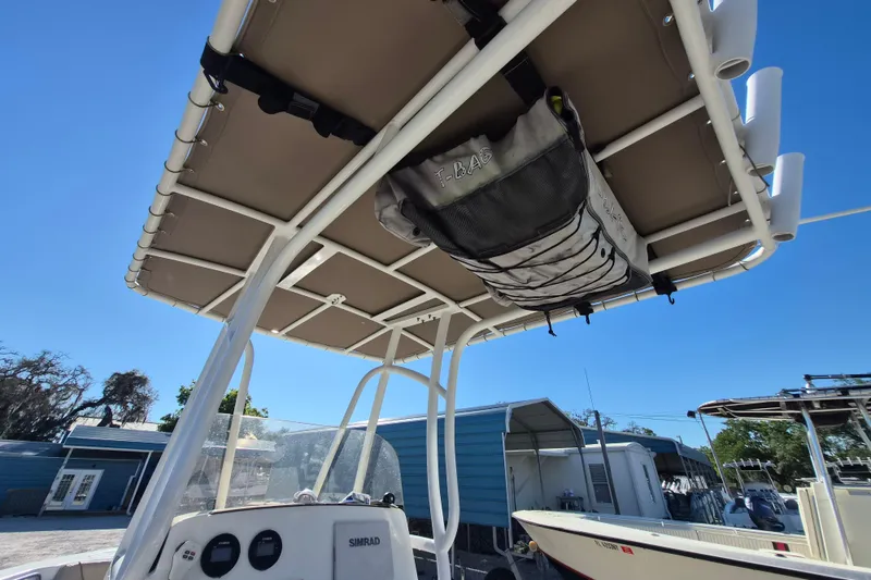 Slide: The Image of 2017 NauticStar 2102 Legacy boat with T-top and storage bag, docked under clear blue sky. - 8