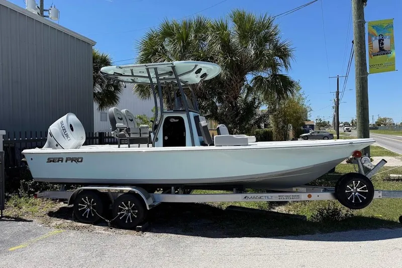 The Image of 2026 Sea Pro 230 Bay boat on trailer, parked outdoors near palm trees. - 1