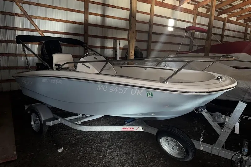 The Image of 2022 Boston Whaler 130 Super Sport boat on trailer in storage shed. - 0