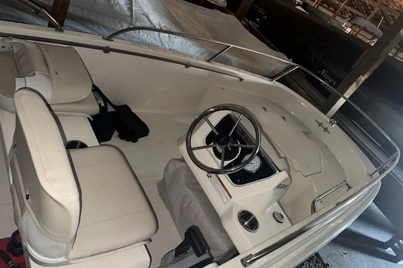 Slide: The Image of 2022 Boston Whaler 130 Super Sport boat interior with steering wheel and seating. - 3