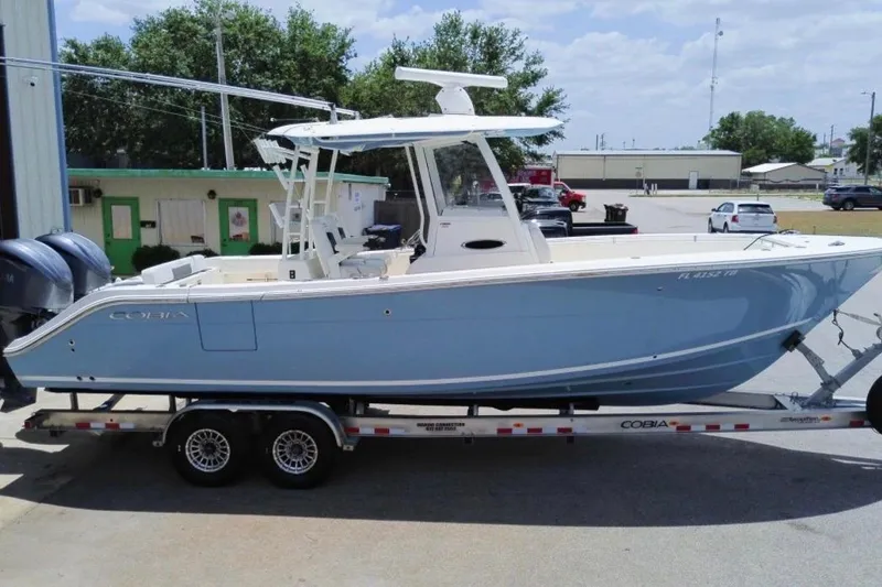 The Image of 2022 Cobia 301 Center Console boat on trailer, parked outdoors. - 0