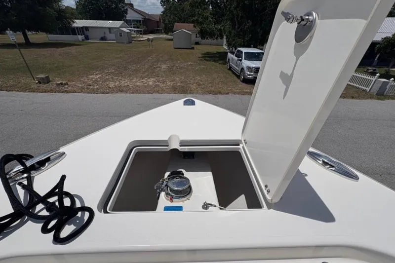 Slide: The Image of 2022 Cobia 301 Center Console boat with open storage compartment on deck. - 11