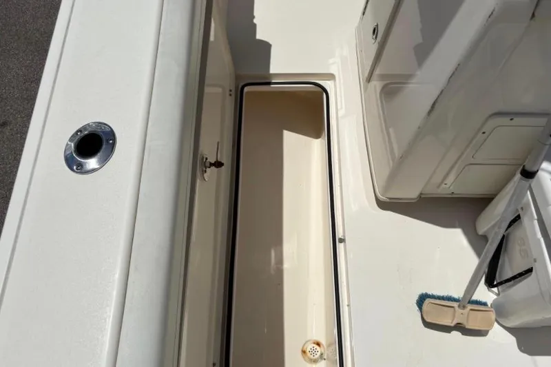 Slide: The Image of 2022 Cobia 301 Center Console boat deck with open storage compartment. - 16