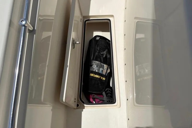 Slide: The Image of Storage compartment on a 2022 Cobia 301 Center Console boat, containing diving gear. - 17