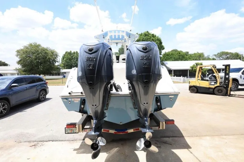 Slide: The Image of 2022 Cobia 301 Center Console with dual 300 V6 engines, parked outdoors. - 3