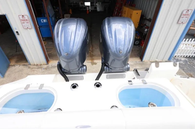 Slide: The Image of 2022 Cobia 301 Center Console with dual outboard engines in a garage setting. - 4