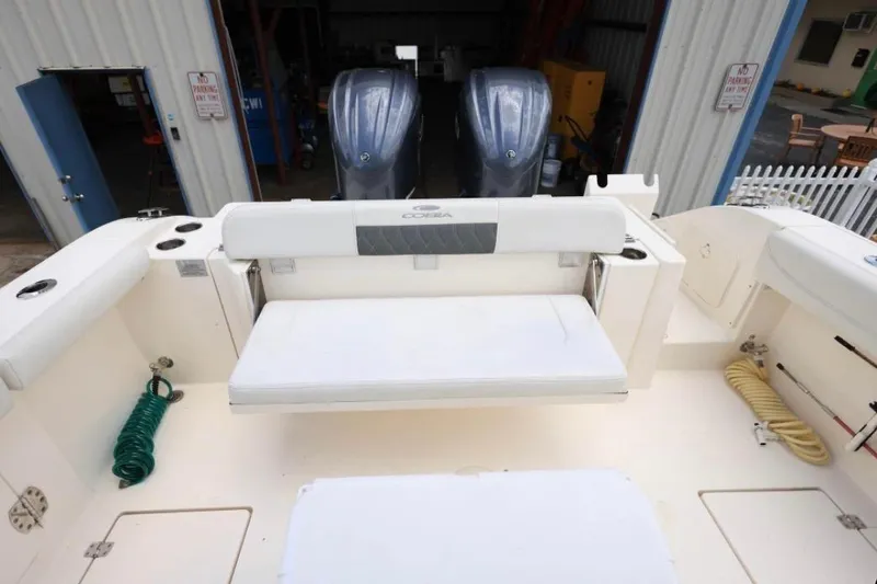 Slide: The Image of 2022 Cobia 301 Center Console boat interior with seating and twin engines. - 5