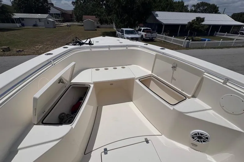 Slide: The Image of 2022 Cobia 301 Center Console boat with open storage compartments and seating area. - 9