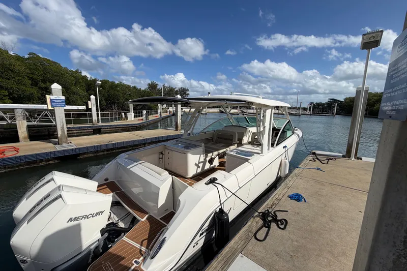 Slide: The Image of 2022 Boston Whaler 320 Vantage docked at a marina under a clear blue sky. - 11