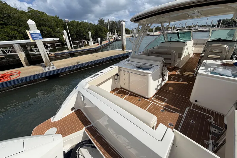 Slide: The Image of 2022 Boston Whaler 320 Vantage docked, showcasing spacious deck and seating area. - 15