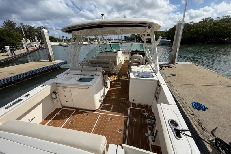 Slide: The Image of 2022 Boston Whaler 320 Vantage docked, showcasing spacious deck and seating area. - 16