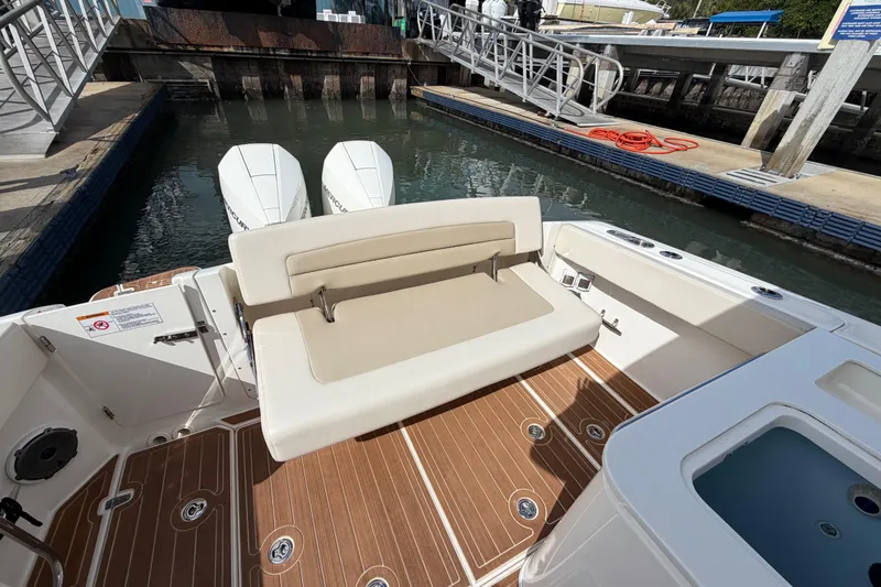 Slide: The Image of 2022 Boston Whaler 320 Vantage boat with cushioned seating and twin outboard engines. - 19