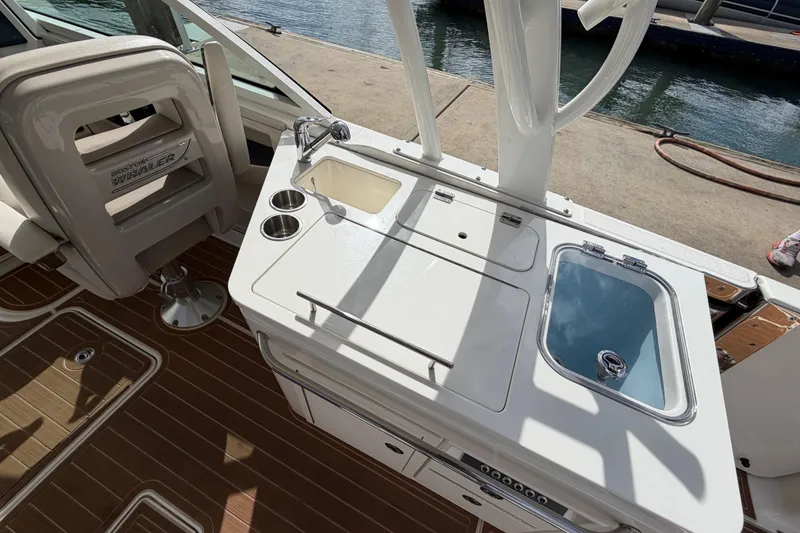Slide: The Image of Boston Whaler 320 Vantage 2022 boat interior with seating and utility area by the water. - 25