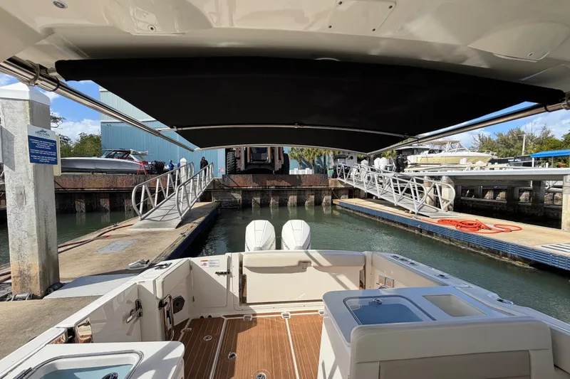 Slide: The Image of 2022 Boston Whaler 320 Vantage docked at marina with canopy and dual engines. - 26