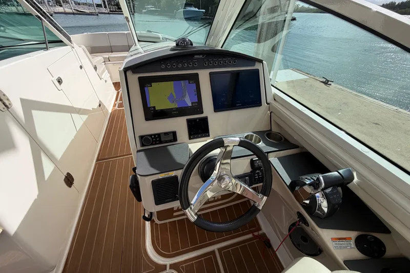 Slide: The Image of Cockpit of 2022 Boston Whaler 320 Vantage with navigation screens and steering wheel. - 28
