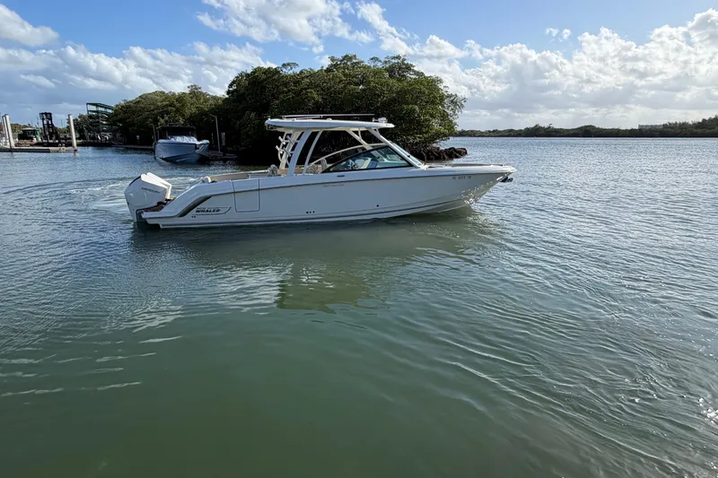 Slide: The Image of 2022 Boston Whaler 320 Vantage boat cruising on calm waters under a clear sky. - 3