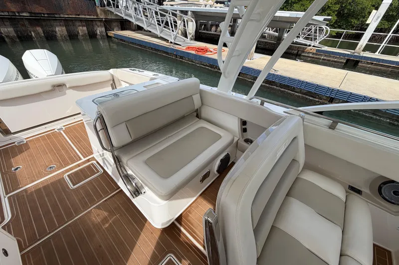 Slide: The Image of 2022 Boston Whaler 320 Vantage boat interior with cushioned seating and wooden flooring. - 31