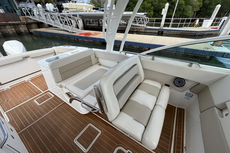 Slide: The Image of 2022 Boston Whaler 320 Vantage boat interior with cushioned seating and wooden flooring. - 32