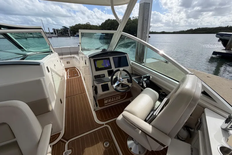 Slide: The Image of 2022 Boston Whaler 320 Vantage boat interior with helm, seating, and water view. - 35