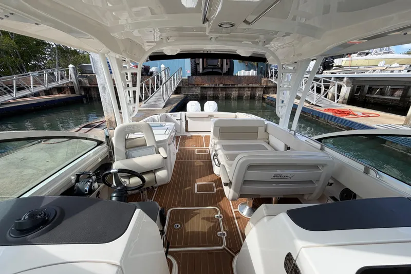 Slide: The Image of 2022 Boston Whaler 320 Vantage boat interior with seating and helm, docked at marina. - 36