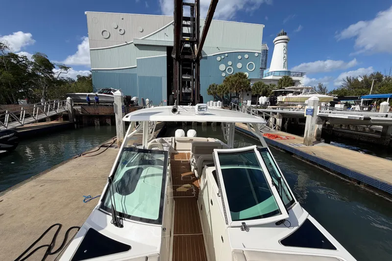 Slide: The Image of 2022 Boston Whaler 320 Vantage docked at marina with modern architecture in background. - 39