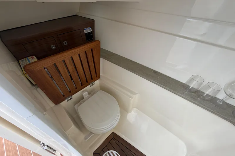 Slide: The Image of 2022 Boston Whaler 320 Vantage boat interior with toilet and wooden accents. - 40