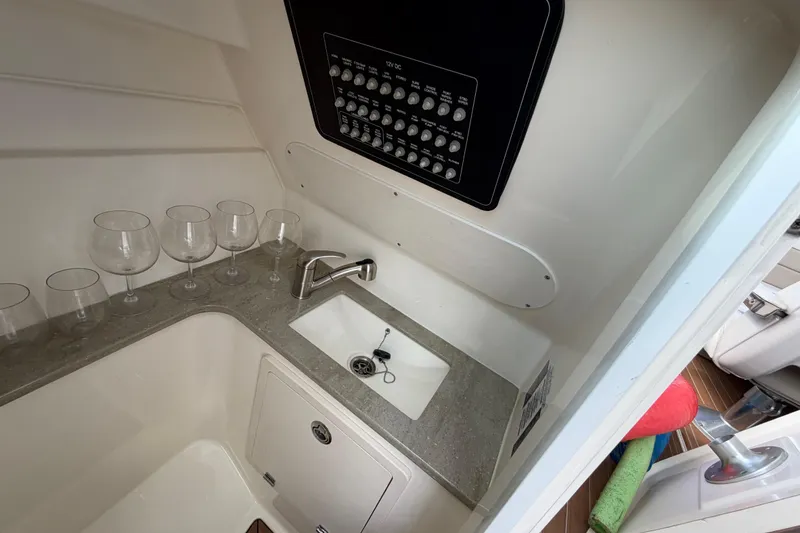 Slide: The Image of Interior of 2022 Boston Whaler 320 Vantage with sink, control panel, and glass holders. - 41