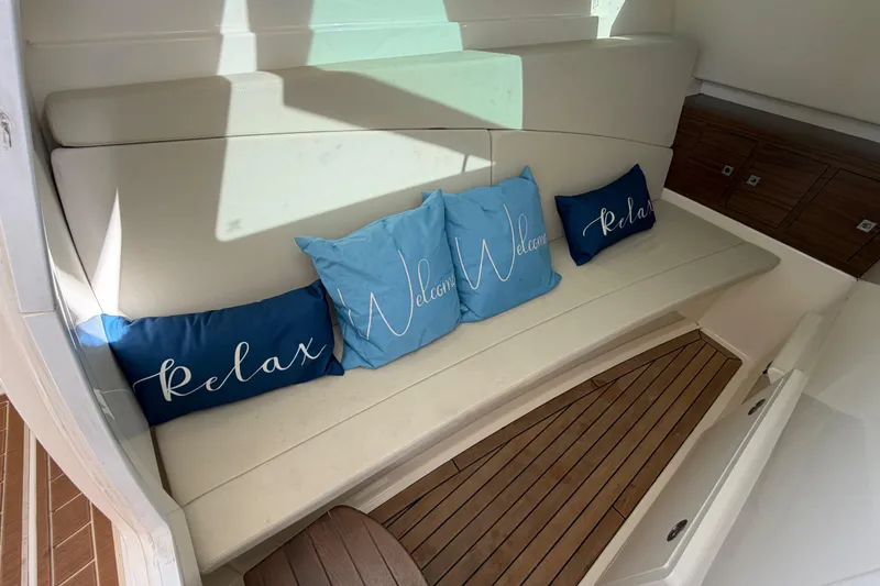 Slide: The Image of Interior of 2022 Boston Whaler 320 Vantage with cushioned seating and decorative pillows. - 43