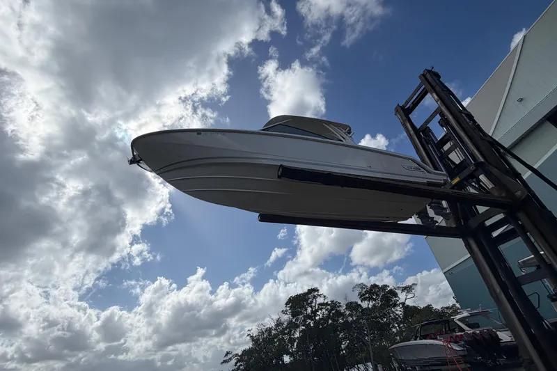 Slide: The Image of 2022 Boston Whaler 320 Vantage boat lifted against a cloudy sky backdrop. - 8