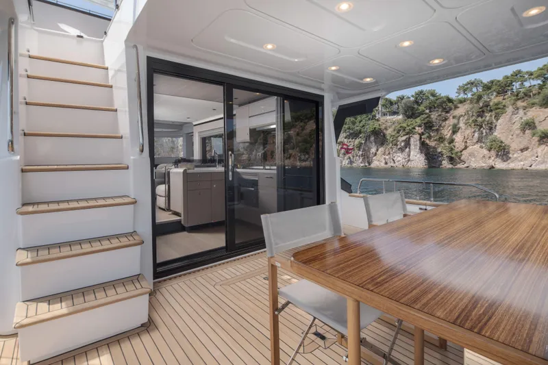 Slide: The Image of Luxurious Sirena 60 yacht interior with wooden table, stairs, and scenic ocean view, 2026 model. - 16
