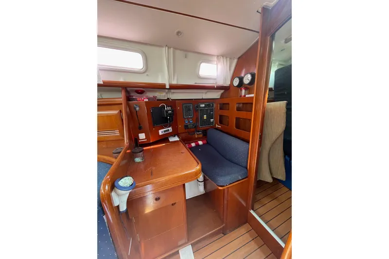 Slide: The Image of Interior of 2004 Beneteau 423 sailboat with navigation station and wooden finish. - 10