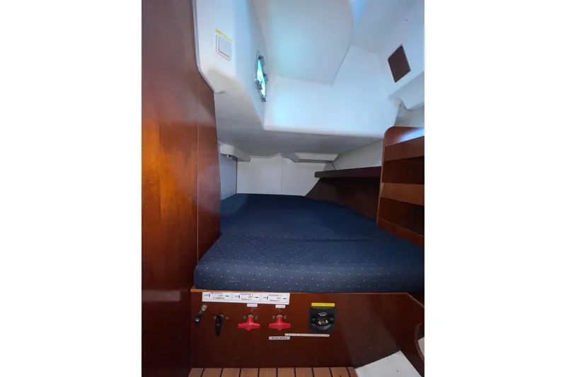 Slide: The Image of Interior cabin of a 2004 Beneteau 423 sailboat with wooden accents and a cozy bed. - 11