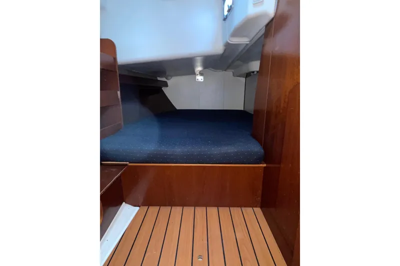 Slide: The Image of Interior cabin of 2004 Beneteau 423 sailboat with wooden flooring and cozy sleeping area. - 12