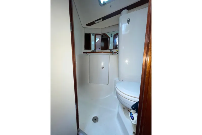Slide: The Image of 2004 Beneteau 423 yacht bathroom with white fixtures and wooden accents. - 14
