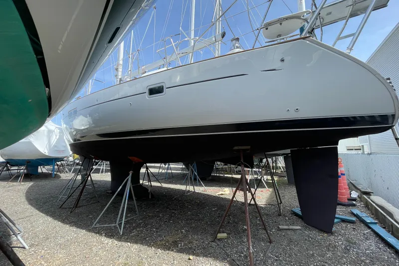 Slide: The Image of 2004 Beneteau 423 sailboat on stands, hull view, in a boatyard. - 3