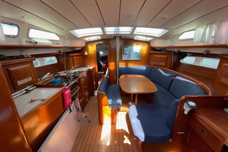 Slide: The Image of Interior of a 2004 Beneteau 423 sailboat with cozy seating and wooden finishes. - 9